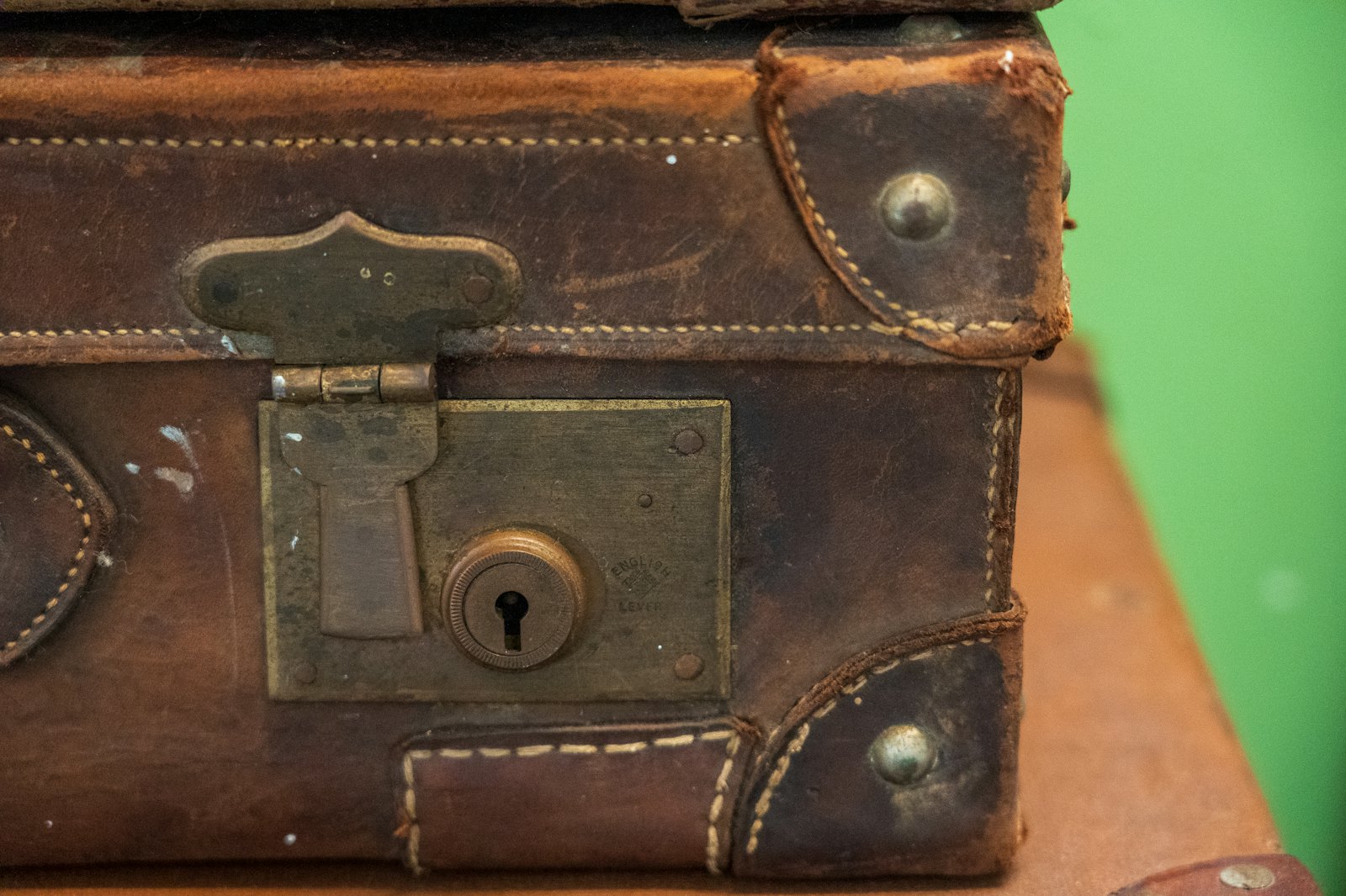 Close-up of a worn leather suitcase.